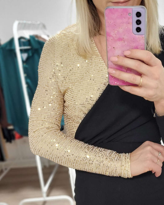 Model präsentiert auf einem weißen Hintergrund Detail Golden Pailletten am rechte Schulter und Arm von dem Langarm-Bleistiftkleid Größe M in Schwarz. Nella Fashion Shop