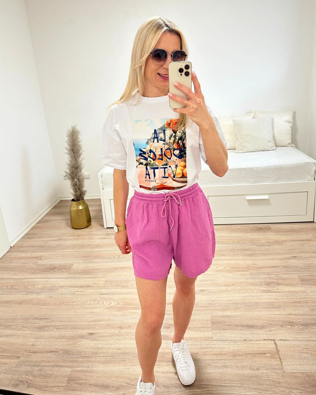 Model präsentiert das Weiße Kurzarm T-Shirt mit Print dazu unseren Minirock im Weiß auf ein Weißenhintergrund, perfektes Sommerlook für Urlaub, Strand oder Unterwegs, jetzt online bestellen bei Nella Fashion Shop