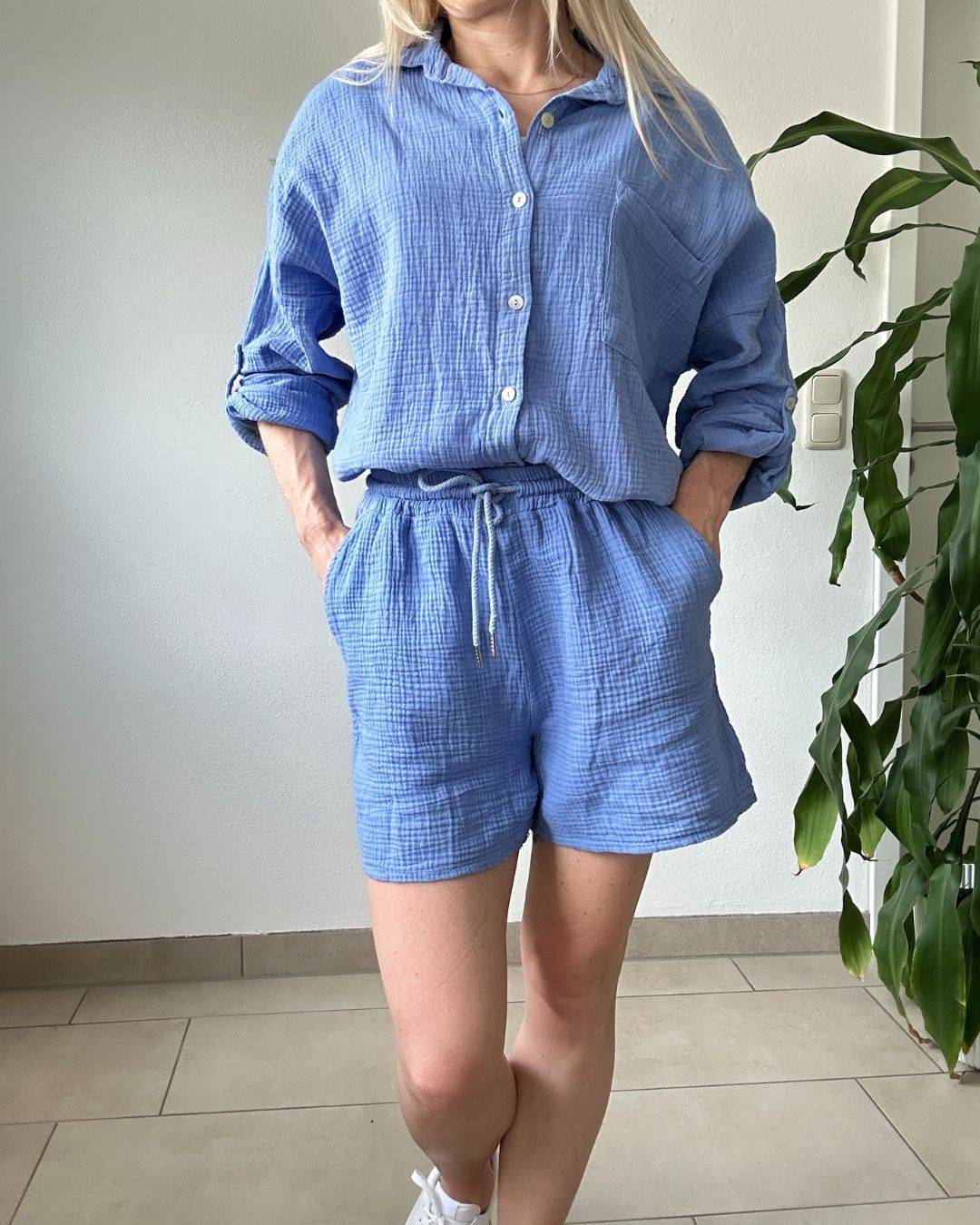 Model trägt das Bequeme Musselin Shorts und Hemd für Damen in Wasserblau, Shorts mit Seitentaschen, Schnur in der Teile und Hemd mit Umschlagkragen, Knöpfen Verschluss in Einheitsgrieße XS bis XL, Ansicht vorne auf ein Weißenhintergrund, Nella Fashion Shop Deutschland