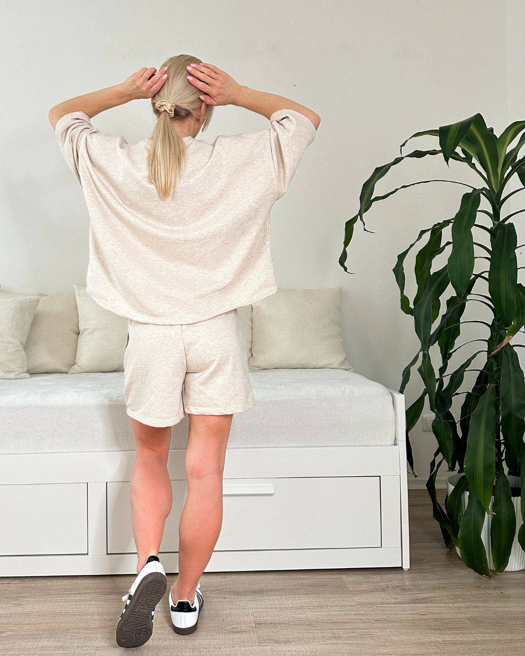Model trägt den bequemen Damen lockeres Oversized T-Shirt mit weiten Armen in Beige, Shorts mit Weißen Schnurdetail in Teile und Seitentaschen aus 95 % Baumwolle, 5 % Polyester, Set ist in Einheitsgroesse XS bis XL von Nella Fashion Shop