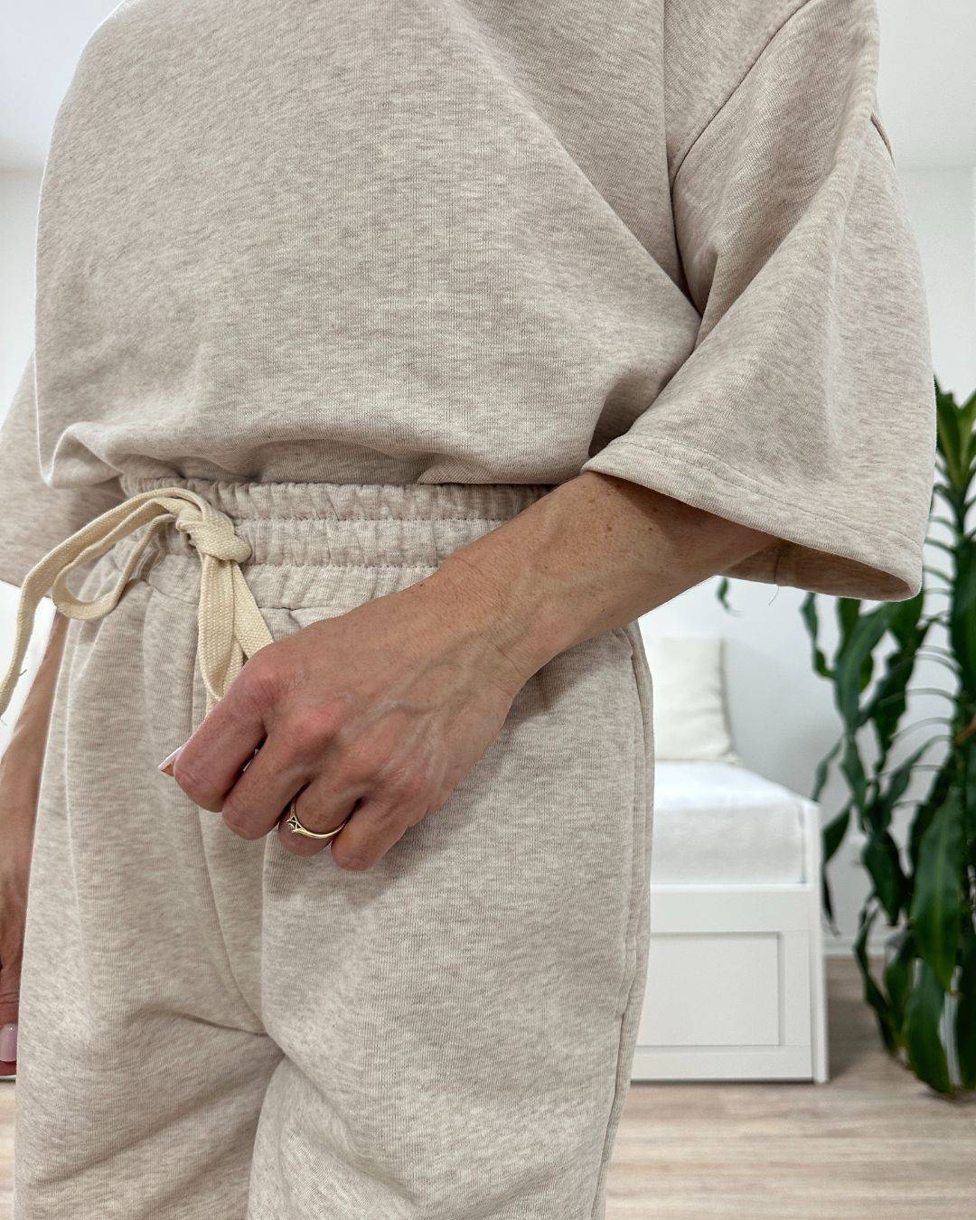 Model trägt den bequemen Damen lockeres Oversized T-Shirt mit weiten Armen in Beige, Shorts mit Weißen Schnurdetail in Teile und Seitentaschen aus 95 % Baumwolle, 5 % Polyester, Set ist in Einheitsgroesse XS bis XL von Nella Fashion Shop
