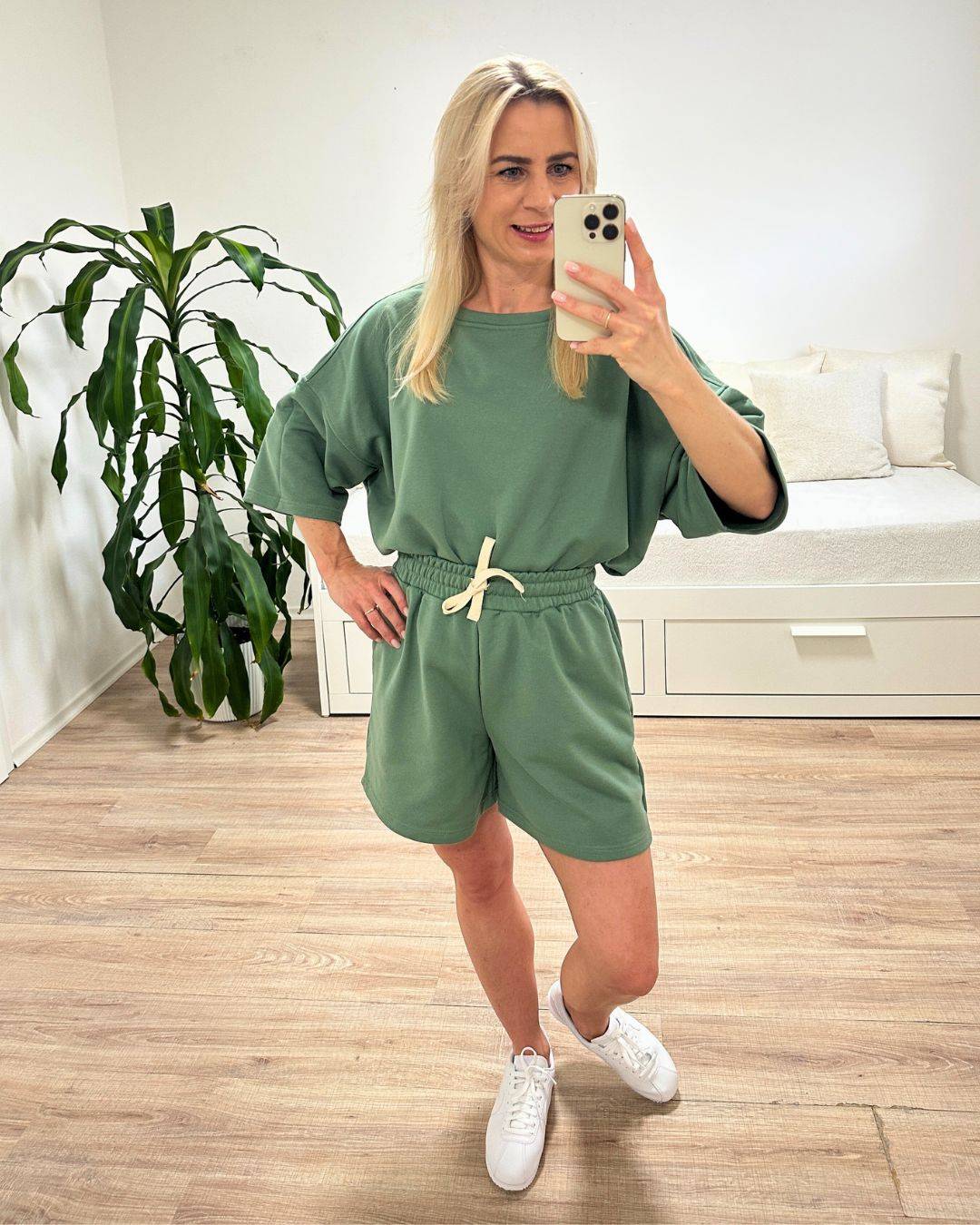 Model trägt den bequemen Damen lockeres Oversized T-Shirt mit weiten Armen in Pistazien-grün, Shorts mit Weißen Schnurdetail in Teile und Seitentaschen aus 95 % Baumwolle, 5 % Polyester, Set ist in Einheitsgroesse XS bis XL von Nella Fashion Shop