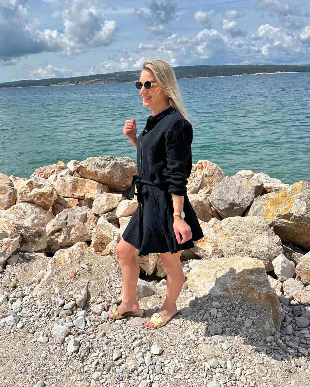 Dieses Model ist 160 cm und trägt Musselin-Kleid in Schwarz, mit einer Schleife in der Teile, Kurz-Mini, leicht, locker, Hintergrund Urlaub kroatisches Meer. Nella Fashion Shop
