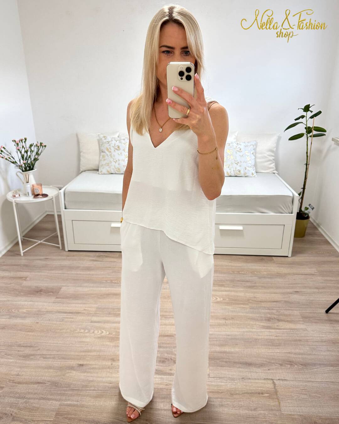 Model ist 160 cm groß und hat das zweiteilige Laura Sommeroutfit für Damen an. Set aus Tank Top mit Tiefen Dekolleté plus Hosen mit weiten Beinen in Weiß. Größe M/L fällt zu groß aus! Hosen sind mit einem hohen Bund und Gummiband in der Taille - elastisch. Der Perfekte Elegant und lässig Strand Style für deinen Urlaub. Alles auf weißen Hintergrund. Nella Fashion Shop