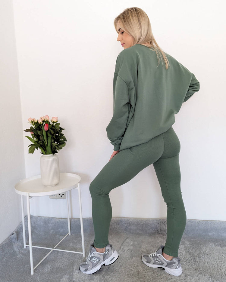 Model präsentiert ein lässiges Damen Oversized Rundhals Sweatshirt und Gerippten Push-up Leggings Set in Einheitsgröße,  auf ein Weißenhintergrund  von Nella Fashion Shop .