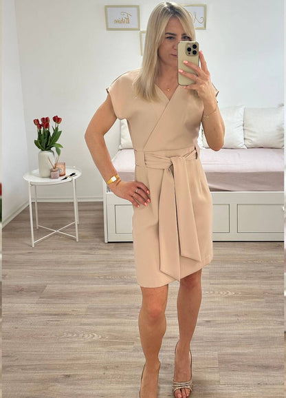 Model ist 160 cm groß und hat das elegantes Umschlagkleid mit V-Ausschnitt OHNE Rüschenärmel in Beige. Das Abendkleid mit der Knielänge für Frauen, mit schlichtem Schnitt und elegantes Style für Anlässe. Gummiband in der Taille. Der Gürtel (Schliefe) lass dem Kleid elegant auszuschauen.  Praktisch auf der Rückseite mit einem Reißverschluss befestigt. Gefertigt aus 100 % Polyester. Hintergrund Weiß. Jetzt bei Nella Fashion Shop Deutschland