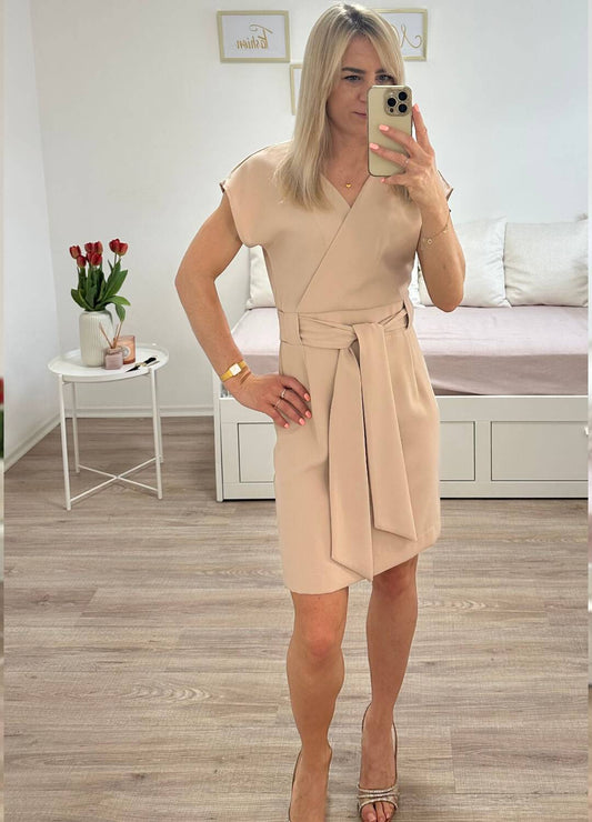 Model ist 160 cm groß und hat das elegantes Umschlagkleid mit V-Ausschnitt OHNE Rüschenärmel in Beige. Das Abendkleid mit der Knielänge für Frauen, mit schlichtem Schnitt und elegantes Style für Anlässe. Gummiband in der Taille. Der Gürtel (Schliefe) lass dem Kleid elegant auszuschauen.  Praktisch auf der Rückseite mit einem Reißverschluss befestigt. Gefertigt aus 100 % Polyester. Hintergrund Weiß. Jetzt bei Nella Fashion Shop Deutschland