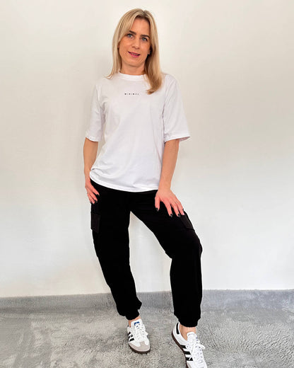 Model ist 160 cm groß und hat unsere Damen Army Cargopants in Trendfarbe Schwarz. In der Einheitsgröße (von XS bis L). Mit einem Gummizug am Knöchel und an der Teile. Große Seitentaschen mit Funktionalität und Style, ideal für das Outdoor, Freizeit oder lässige Stadtausflüge. Ein Must-have für jede Frau, um ein sportliches, elegantes Outfit zu haben. Alles auf ein Weißenhintergrund, Nella Fashion Online Shop   