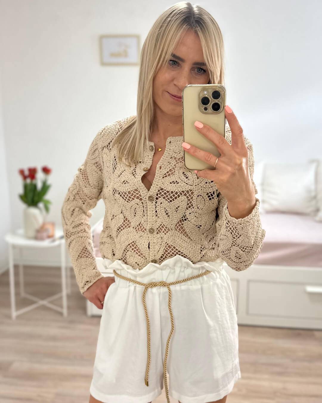 Model präsentiert die Damen Sommeroutfit: Damen Boho Pullover in Biege kombiniert mit weißen hoch taillierte Damenshorts in Einheitsgröße von XS bis L, mit elastischem Bund (Gummiband) in der Taille und einer goldenen Schnur zuzüglich Seitentaschen. Perfekter Sommer Outfit. Hintergrund Weiß. Jetzt bei Nella Fashion Shop Deutschland
