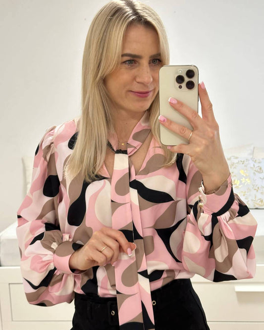 Model ist 160 cm groß und trägt Hemd mit V-Ausschnitt in Abstract mit Rosa-Weiß-Schwarz und Braunen Farben. Das Hemd ist Langarm mit Schleife am Hals, somit kann eine Krawatte gemacht werden. Alles auf ein Weißenhintergrund, Nella Fashion Online-Shop  