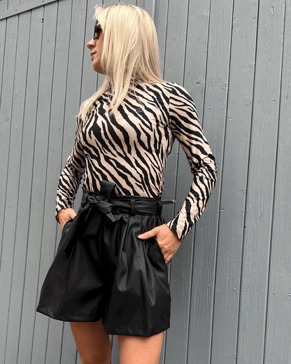 Das Model präsentiert Damen Herbst Outfit Kunstleder Shorts Schwarz in XS mit Damen Rollkragenpullover Zebramuster S, Nella Fashion Shop  