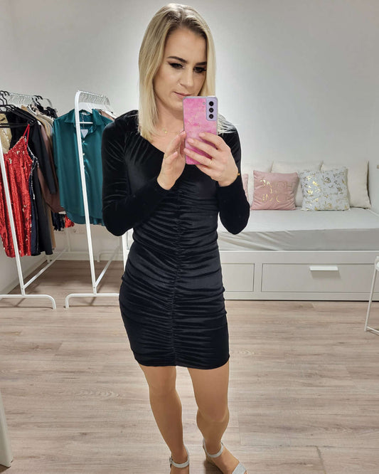 Model ist 160 cm groß und präsentiert das schwarze Mini-Kleid mit Langarm aus 70 % Baumwolle / 12 % Polyester / 18 % Lycra. Sexy & Figurbetont dank geknitterte Vorderseite und V-Ausschnitt.  Alles auf weißen Hintergrund. Nella Fashion Shop 
