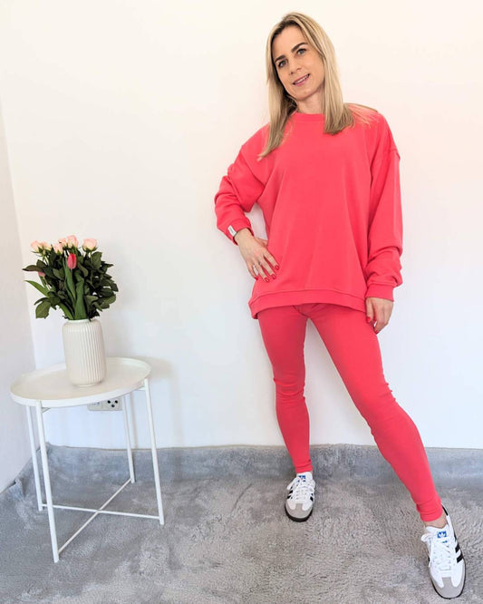Model ist 160 cm und trägt das Oversized Lang Sweatshirt in der Einheitsgröße von XS bis L mit gerippten dehnbaren Push-up-Leggings mit hohem Bund in XS/S und M/L.  In Wassermelonen-Rosa Trendfarbe aus Baumwolle weibliche Alltags-Leggings, auf ein Weißenhintergrund, Nella Fashion Shop 