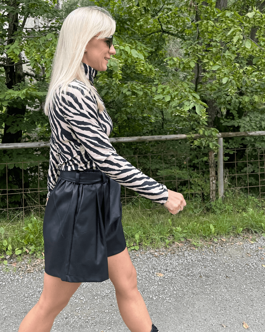 Model ist 160 cm groß und hat die Kunstleder Shorts Schwarz in Größe XS mit Damen Rollkragenpullover Zebramuster in Größe S an. Sehr weicher Stoff 95 % Baumwolle. Hintergrund Spazieren in Park.  