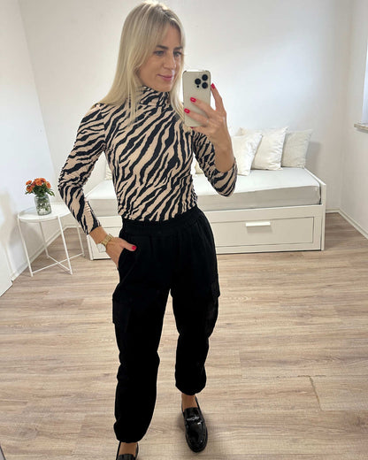 Unser Model ist 160 cm und präsentiert Rollkragenpullover in Zebramuster, Größe S, M oder L dazu Damen Army Cargopants Schwarz, Einheitsgröße von XS bis L. Jetzt Kaufen bei Nella & Fashion Shop
