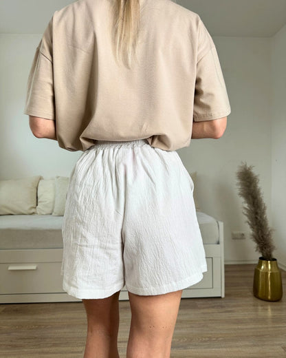 Model trägt die Weißen Hochteiler Shorts mit Gummibund in Teile. Alles auf ein Weißenhintergrund, Nella Fashion Shop dein Online-Shop   