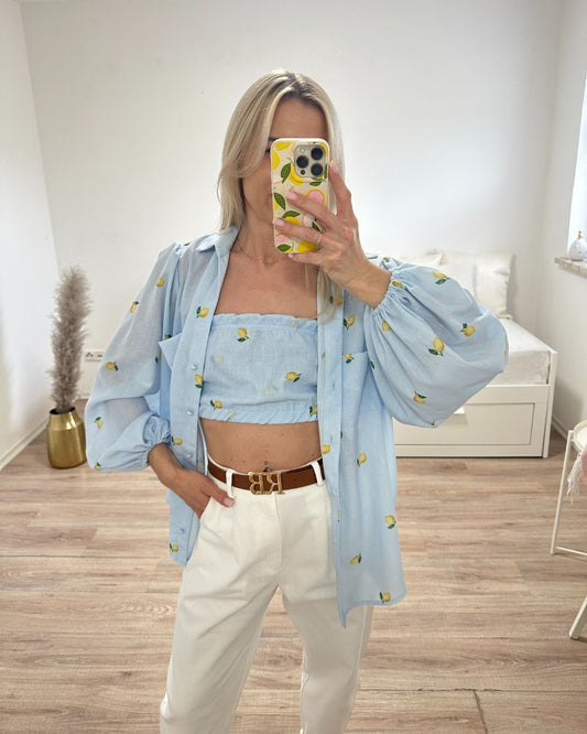 Model ist 160 cm groß, trägt das Wasserblaue mit Zitronenmuster, Umschlagkragen, Langarm-Hemd geöffnet, mit armlosem Top, mit 2 elastischem Gummibänder, gleicher Farbe aus 100 % Baumwolle, Hemd hat zwei Brusttaschen und elastischen Gummiband am Arm, alles auf ein Weißenhintergrund, Nella Fashion Shop Onlineshop