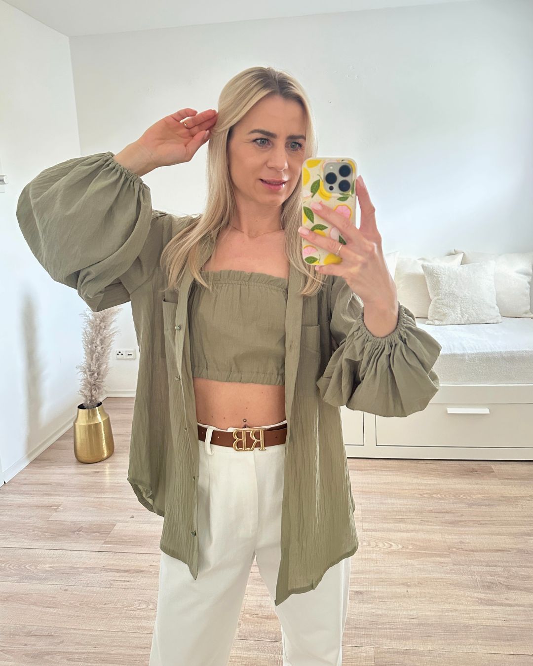 Model ist 160 cm groß, trägt das Pistazien Grün Umschlagkragen, Langarm-Hemd geöffnet, mit armlosem Top, mit 2 elastischem Gummibänder, gleicher Farbe aus 100 % Baumwolle, Hemd hat zwei Brusttaschen und elastischen Gummiband am Arm, alles auf ein Weißenhintergrund, Nella Fashion Shop Onlineshop