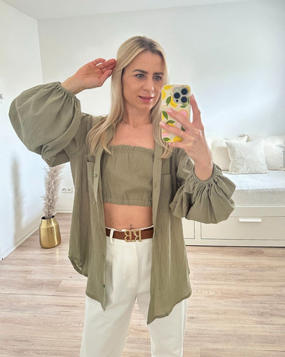 Model ist 160 cm groß, trägt das Pistazien Grün Umschlagkragen, Langarm-Hemd geöffnet, mit armlosem Top, mit 2 elastischem Gummibänder, gleicher Farbe aus 100 % Baumwolle, Hemd hat zwei Brusttaschen und elastischen Gummiband am Arm, alles auf ein Weißenhintergrund, Nella Fashion Shop Onlineshop