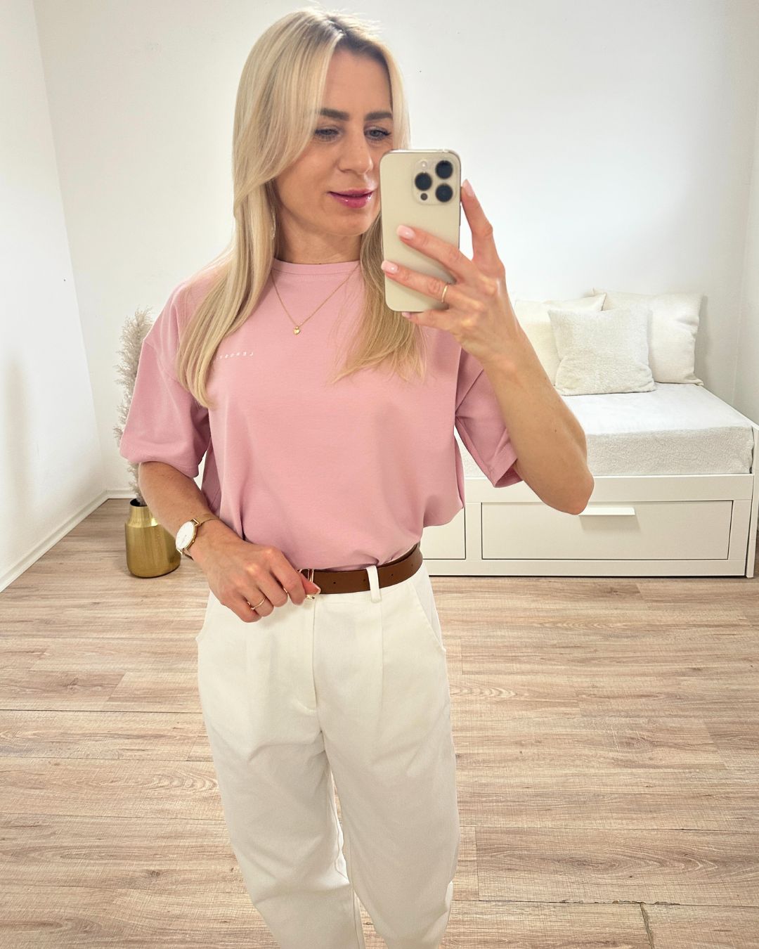 Model präsentiert das bequeme Rosa Rundhals Damen T-Shirt aus 95 % Baumwolle und 5 % Elastan, auf ein Weißenhintergrund, Accessoires: Gürtel, Armbanduhr, Handy, Nella Fashion Shop Onlineshop
