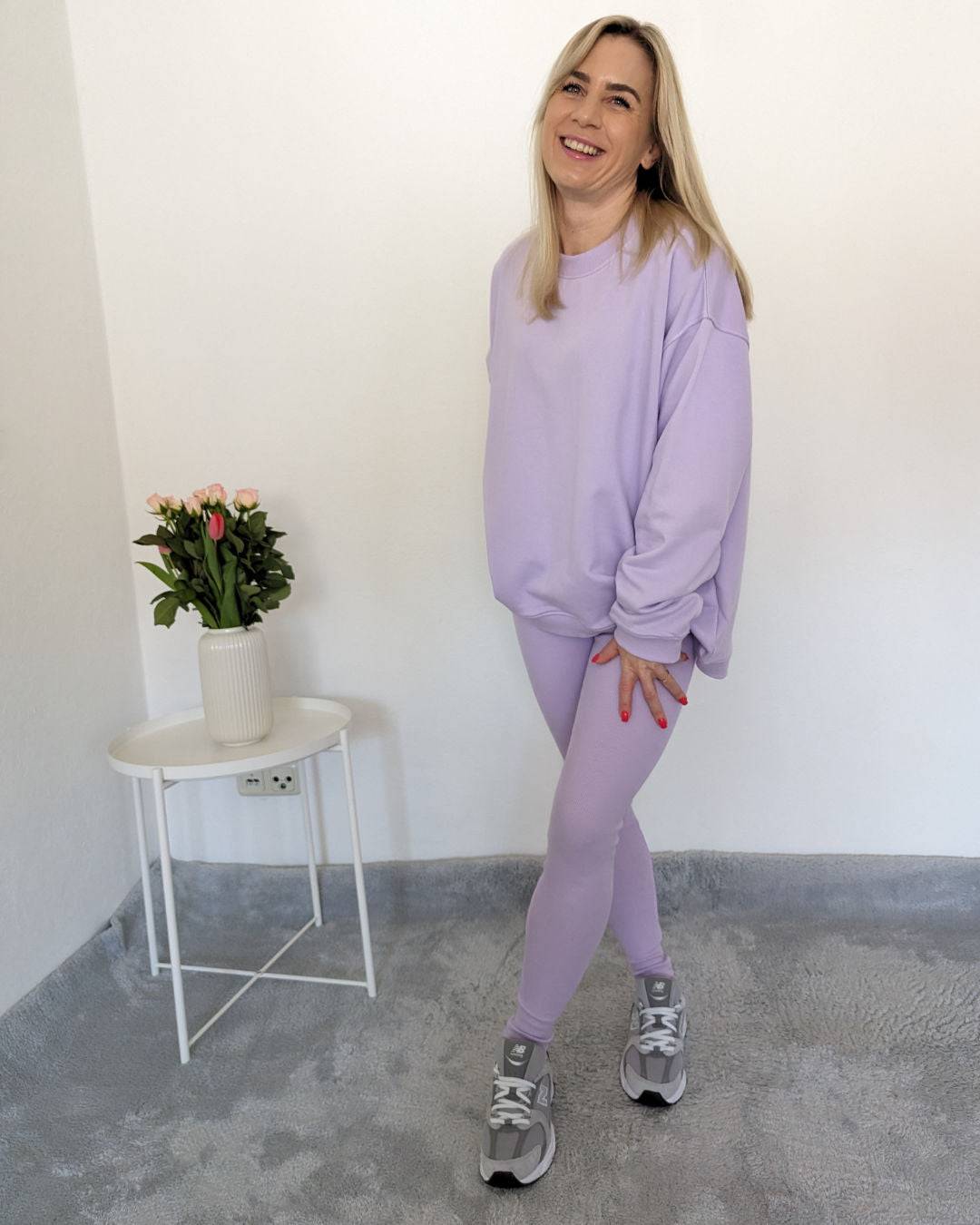 Model präsentiert das Damen Oversized Sweatshirt in der Einheitsgröße von XS bis L mit gerippten dehnbaren Push-up-Leggings mit hohem Bund in XS/S und M/L Größe. In Hell Lila Trendfarbe, auf ein Weißen-Hintergrund, Nella Fashion Shop 