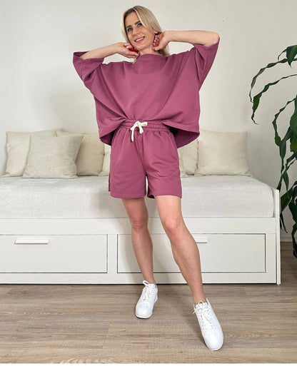 Model trägt den bequemen Damen lockeres Oversized T-Shirt mit weiten Armen in Beerenfarbe, Shorts mit Schnurdetail in Teile und Seitentaschen, Set ist in Einheitsgroesse XS bis XL von Nella Fashion Shop