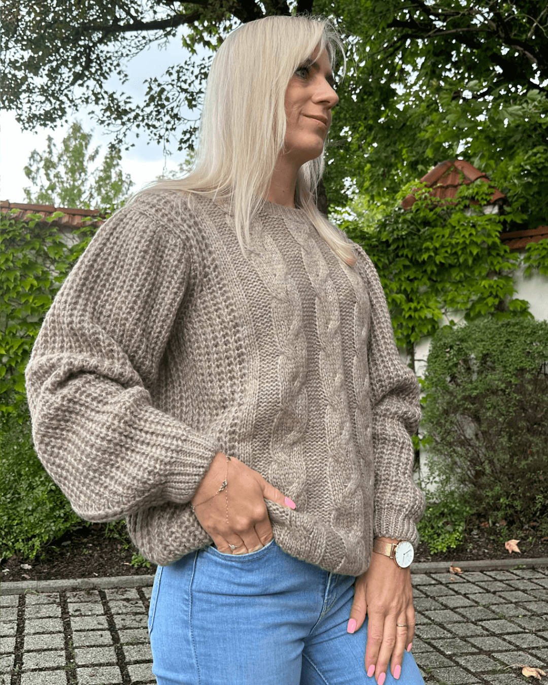 Model präsentiert Oversized-Strickpullover in Beige mit einem wunderschönen Zopfmuster Langarm in der Einheitsgröße XS/L alles in einen Park bei Spazieren. Nella Fashion Shop