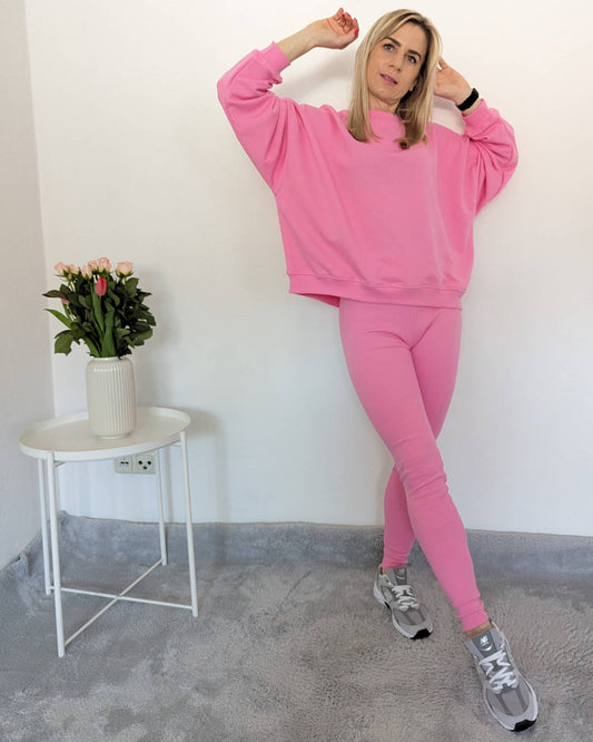Kurze Damen Oversized Sweatshirt XXL - Format weiten Arm mit Gerippten Push-up Leggings mit hohem Bund in Baumwollmix weibliche Alltags-Leggings in Hell Rosa auf ein Weißenhintergrund 