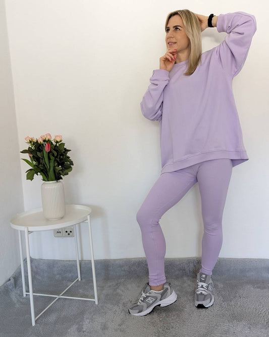 Dieses Model ist 160 cm groß und trägt Damen Oversized Sweatshirt Einheitsgröße XS-M mit gerippten Push-up-Leggings mit hohem Bund in XS/S und M/L Größe. In Hell Lila, auf Weißen Hintergrund, Nella Fashion Shop