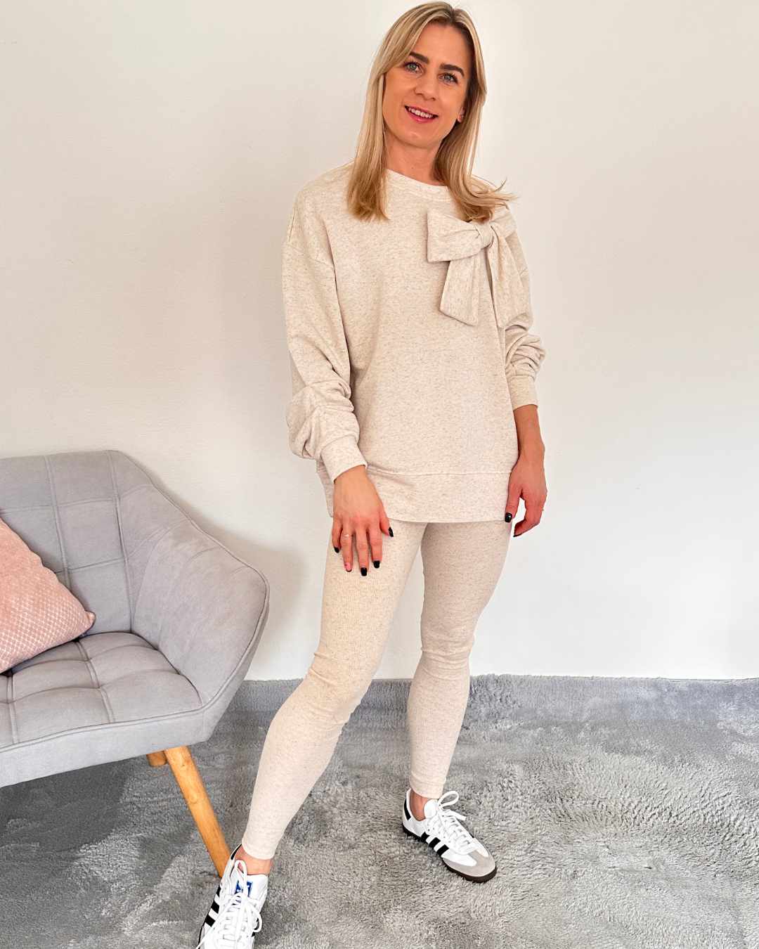 Model ist 160 cm groß und hat das beige Oversized-Sweatshirt Beige mit einer Großen, Süßen Schleife vorne. Zusammen mit Leggings ist das ein perfektes Set für Damen. Jetzt bei Nella Fashion Online-Shop   