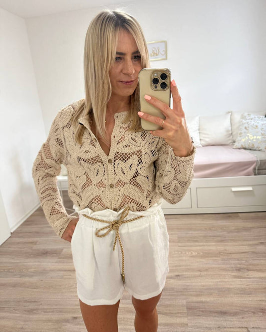 Model präsentiert Sommeroutfit für Damen Boho Pullover mit weißen Shorts. Hoch taillierte weiße Damenshorts in Einheitsgröße von XS bis L, mit elastischem Bund (Gummiband) in der Taille und einer goldenen Schnur zuzüglich Seitentaschen. Shorts sind aus 95 % Polyester / 5 % Elastan Mischung. Hintergrund Weiß. Jetzt bei Nella Fashion Shop Deutschland
