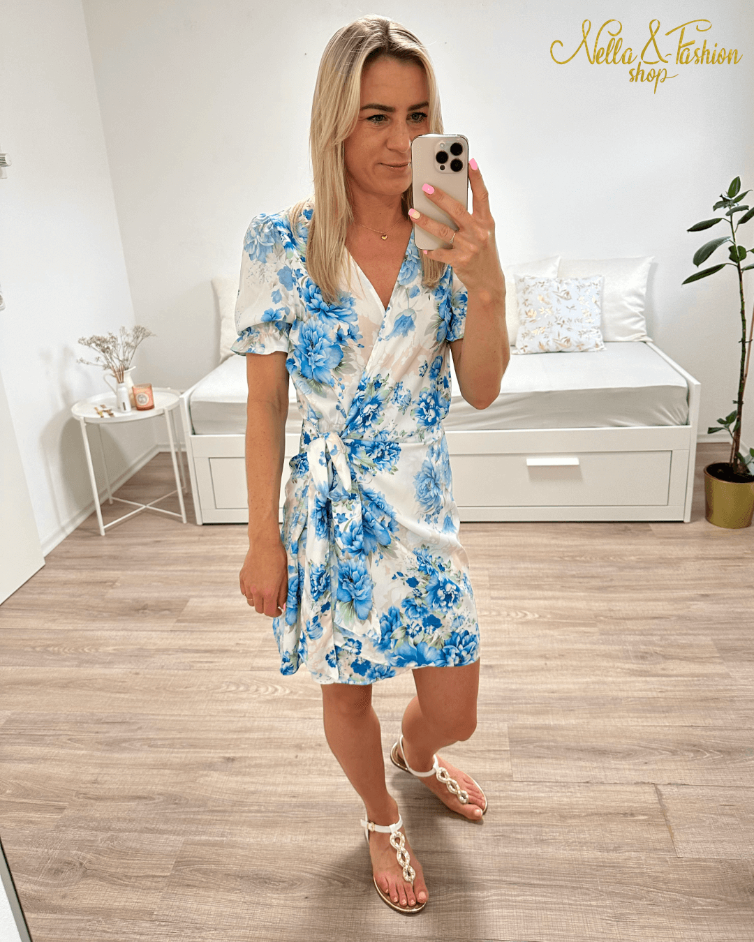 Das Model trägt das bunte Wickelkleid mit Blumenmuster in Blau; idealer Sommer-Look kombiniert mit Accessoires.wie für Sommertage.