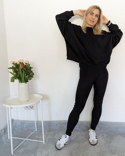 Kurze Damen Oversized Sweatshirt XXL - Format mit passenden gerippten Push-up Leggings mit hohem Bund, Baumwollmix weibliche Alltags-Leggings in Schwarz auf ein Weißenhintergrund 