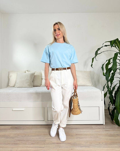 Model präsentiert das bequeme Babyblue Rundhals Damen T-Shirt aus 95 % Baumwolle und 5 % Elastan, Größe XS bis L, dazu unsere Damenhosen in Ecru auf ein Weißenhintergrund, perfektes Outfit für unterwegs oder Alltag, Accessoires: Gürtel, Handtasche, Schuhe, Nella Fashion Shop Onlineshop
