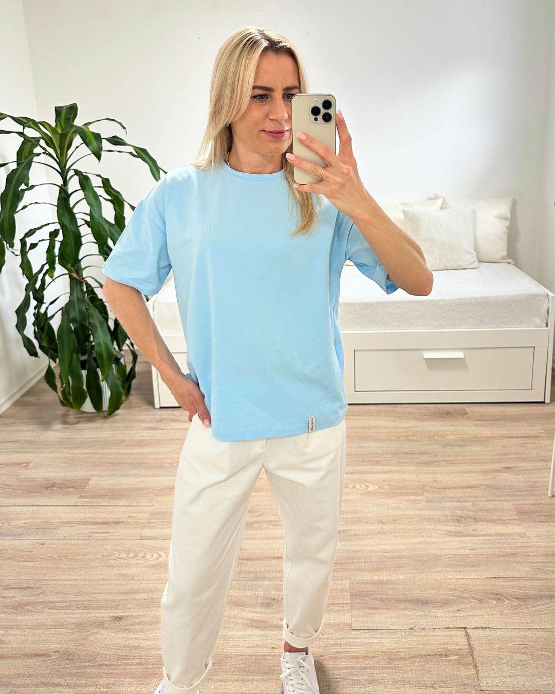 Model präsentiert das Babyblue Damen T-Shirt aus 95 % Baumwolle und 5 % Elastan, bequeme Passform, Größen XS bis L, dazu unsere Damenhosen in Ecru, auf ein Weißenhintergrund, Nella Fashion Shop Deutschland

